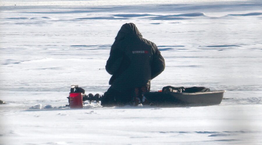 A lone ice fisherman out on the lake. Ice fishing is major recreation in Minnesota.